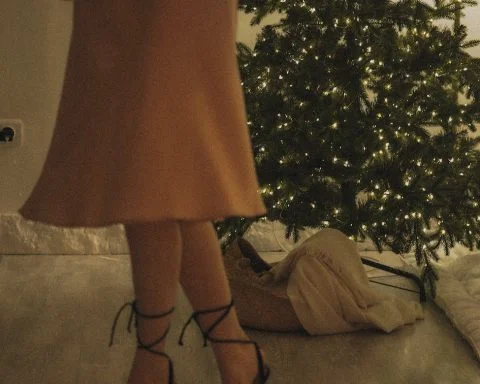 low section of woman standing in front of christmas tree