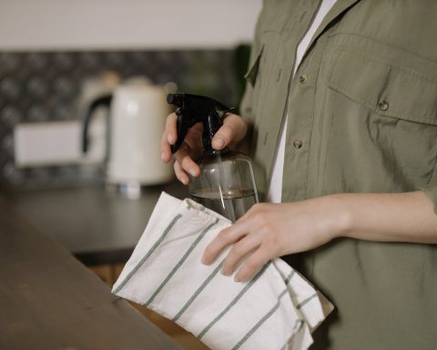 person in green button up shirt holding clear drinking glass